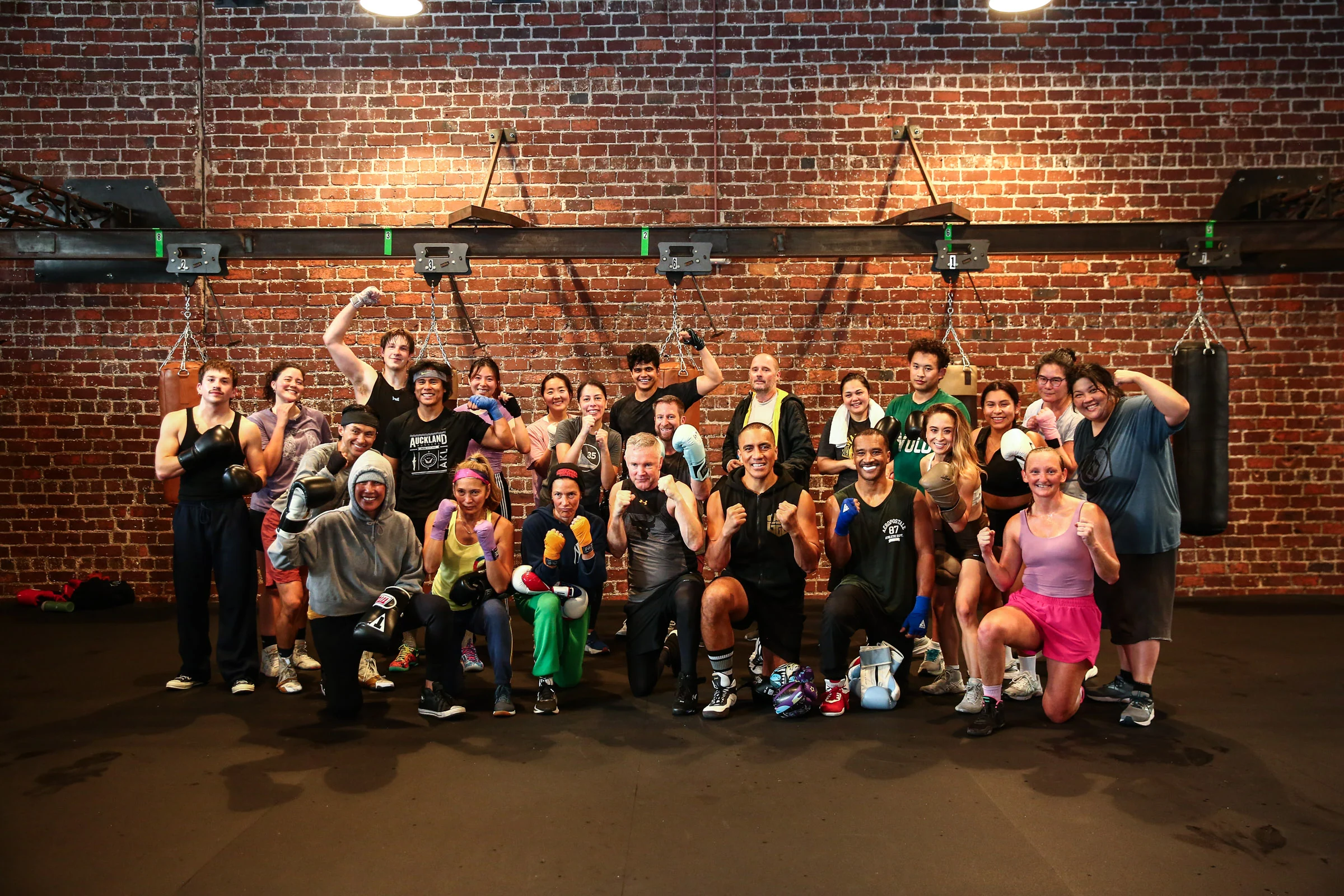 GGG members and coaches celebrating together in front of the brick wall